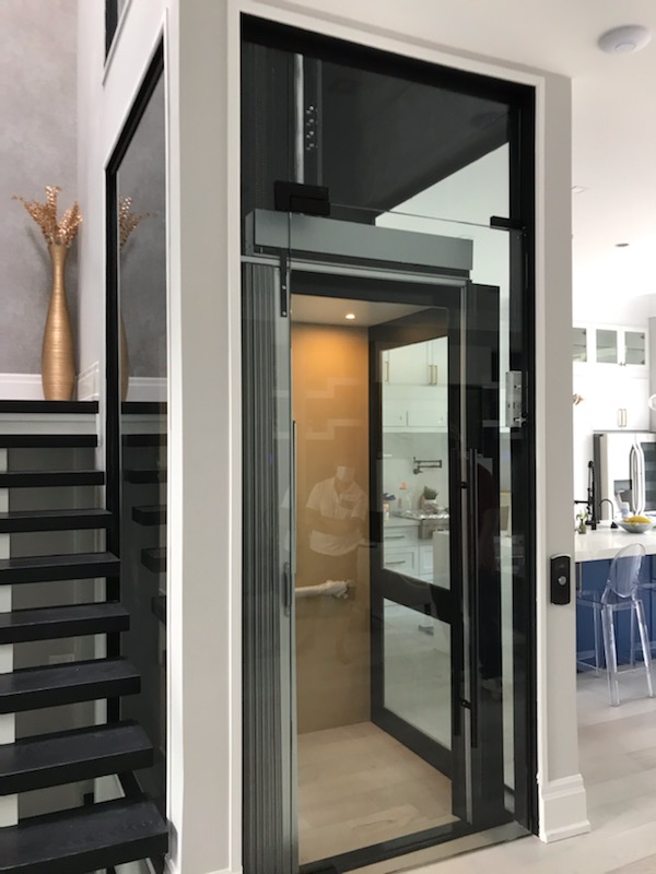 Home Elevator with glass shaft and door in private residence