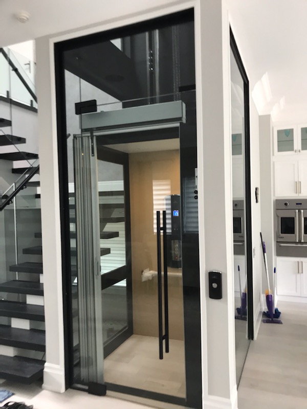 Home Elevator with glass shaft and door in private residence