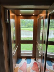 Windowed home elevator overlooking a pond and golf course in Dakota Dunes