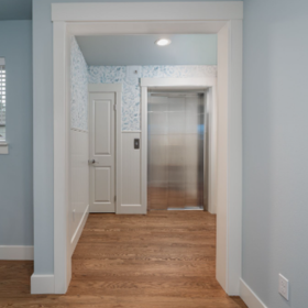 Open home elevator showing its stainless steel interior and tiled floor in an Edmonds, WA home